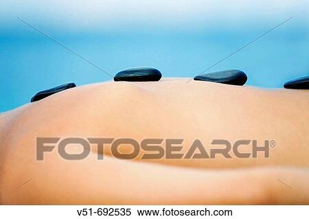 Stock Photography - Detail of a woman having a massage by the sea. Fotosearch