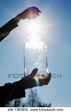 Detail of person? catching? the sun in a glass jar. View Large Photo Image Stock Image - Detail of person? catching? the sun in a glass jar.. Fotosearch