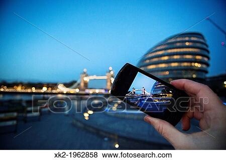 Detail of tourist's hand taking pictures of City Hall and Tower bridge with a camera, London, UK View Large Photo Image Stock Photo - Detail of tourist's hand taking pictures of City Hall and Tower bridge with a camera, London, UK. Fotosearch