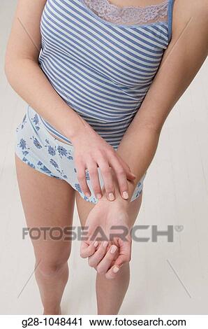 detail of young woman scratching herself because of an itching sensation View Large Photo Image Stock Image - detail of young woman scratching herself because of an itching sensation. Fotosearch
