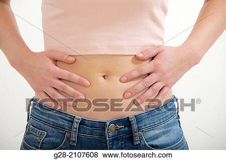 Detail of young woman's stomach with hands on her hips, for pain, stomach ache, or periods pains View Large Photo Image Stock Photo - Detail of young woman's stomach with hands on her hips, for pain, stomach ache, or periods pains. Fotosearch