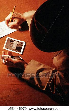 Detective looking at photographs View Large Photo Image Stock Photo - Detective looking at photographs. Fotosearch