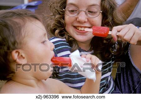 Detroit, Michigan - Mariel West right and Jake Damle share popsicles on a hot, summer afternoon MR View Large Photo Image Stock Photograph - Detroit, Michigan - Mariel West right and Jake Damle share popsicles on a hot, summer afternoon MR. Fotosearch