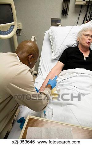 Detroit, Michigan - Oncology technician Tyletta Sullivan starts an IV so that chemotherapy can be administered to Pat Lancaster View Large Photo Image Stock Photograph - Detroit, Michigan - Oncology technician Tyletta Sullivan starts an IV so that chemotherapy can be administered to Pat Lancaster . Fotosearch