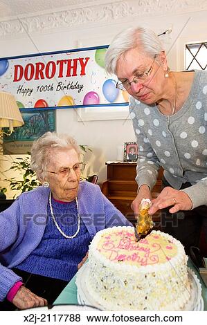 Detroit, Michigan - Woman celebrates her 100th birthday. Her daughter cuts the birthday cake. View Large Photo Image Stock Photo - Detroit, Michigan - Woman celebrates her 100th birthday. Her daughter cuts the birthday cake.. Fotosearch