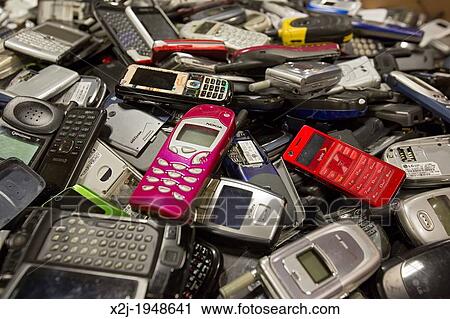 Stock Image - Dexter, Michigan - Cell phone recycling at ReCellular, Inc. The company collects used phones, inspects and repairs them, and resells them. These old phones could not be resold, so the components will be recycled.. Fotosearch