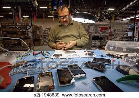 Stock Photo - Dexter, Michigan - Cell phone recycling at ReCellular, Inc. The company collects used phones, inspects and repairs them, and resells them. Some of the work is done for charities, which collect used phones and profit from the re-sales.. Fotosearch