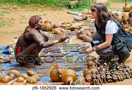 Dimeka Ethiopia Africa Lower Omo Valley market with Bena native woman selling to tourist souvenirs on ground 17 View Large Photo Image Stock Photograph - Dimeka Ethiopia Africa Lower Omo Valley market with Bena native woman selling to tourist souvenirs on ground 17. Fotosearch