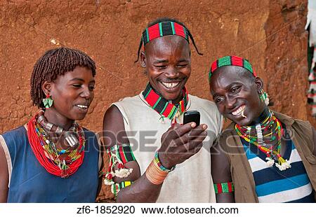 Dimeka Ethiopia Africa village Lower Omo Valley portrait of young Hamar guys and girl texting with cell phone communicating 18 View Large Photo Image Stock Image - Dimeka Ethiopia Africa village Lower Omo Valley portrait of young Hamar guys and girl texting with cell phone communicating 18. Fotosearch