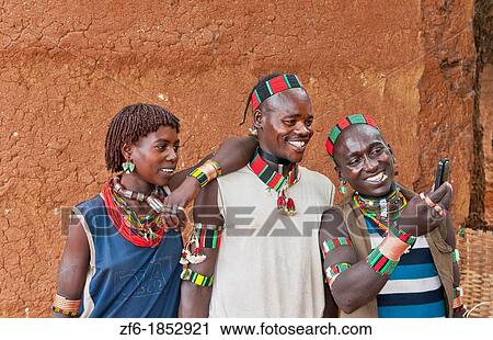Dimeka Ethiopia Africa village Lower Omo Valley portrait of young Hamar guys and girl taking picture with cell phone laughing 18 View Large Photo Image Stock Image - Dimeka Ethiopia Africa village Lower Omo Valley portrait of young Hamar guys and girl taking picture with cell phone laughing 18. Fotosearch