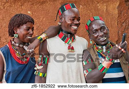 Dimeka Ethiopia Africa village Lower Omo Valley portrait of young Hamar guys and girl taking picture with cell phone laughing 18 View Large Photo Image Stock Image - Dimeka Ethiopia Africa village Lower Omo Valley portrait of young Hamar guys and girl taking picture with cell phone laughing 18. Fotosearch