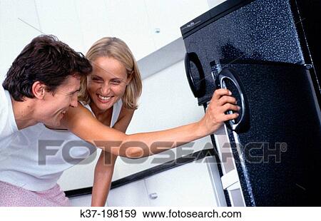 Stock Photo - Dinner decisions made by looking in fridge. Fotosearch