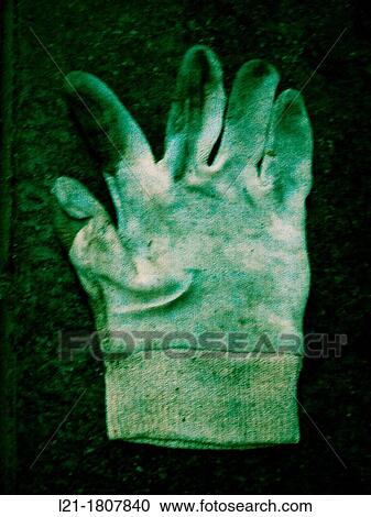 Stock Image - Dirty glove on the ground.. Fotosearch
