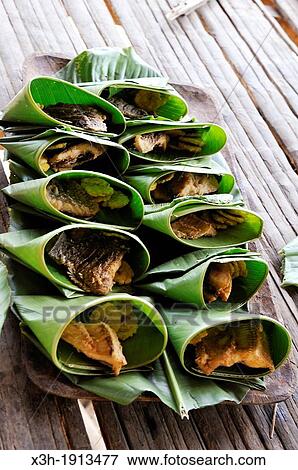 dishes of fish wrapped in leaves, Embera native community living by the Chagres River within the Chagres National Park, Republic of Panama, Central America View Large Photo Image Stock Photo - dishes of fish wrapped in leaves, Embera native community living by the Chagres River within the Chagres National Park, Republic of Panama, Central America. Fotosearch