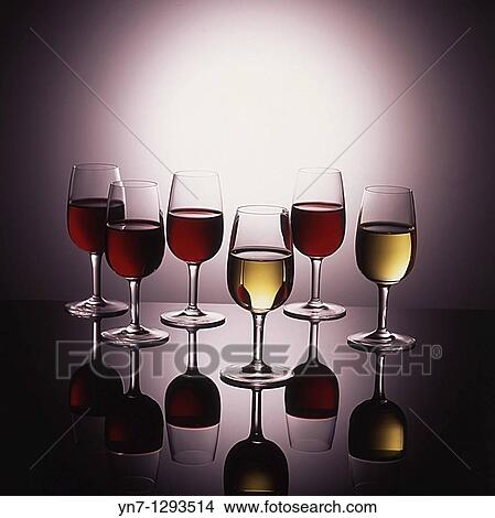 Display of wine in glasses on glowing background with reflections View Large Photo Image Picture - Display of wine in glasses on glowing background with reflections. Fotosearch