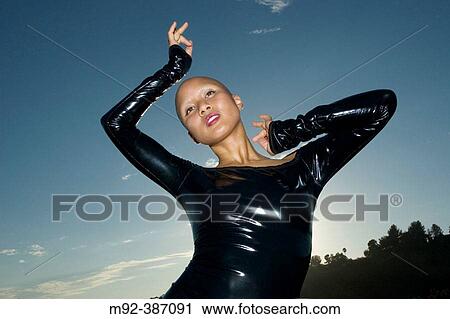Diva in Latex With Dark Sky. This shot was made in Grifith Park, Los Angeles, California. On September 9, 2004. The model actually shaved her head for this shoot. The Sun was directly behind the model. She was lit with strobes. View Large Photo Image Stock Image - Diva in Latex With Dark Sky. This shot was made in Grifith Park, Los Angeles, California. On September 9, 2004. The model actually shaved her head for this shoot. The Sun was directly behind the model. She was lit with strobes.. Fotosearch