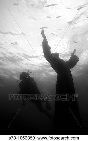 Stock Image - Diver and Christ of the Abyss statue (Florida). Fotosearch