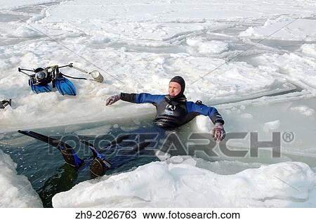 Stock Image - Diver, preparing for subglacial diving, ice diving, in the frozen Black Sea, a rare phenomenon, last time it occured in 1977, Odessa, Ukraine, Eastern Europe.. Fotosearch