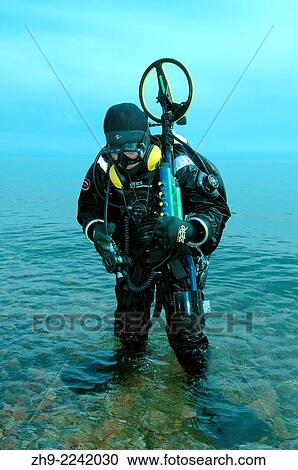 Stock Image - Diver with the metal detector searching for underwater treasure, lake Baikal, Siberia, Russia, Eurasia.. Fotosearch