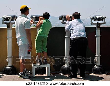 DMZ Zone (South Korea): tourists watching North Korea with binoculars from the South Korean base of Dora Observatory View Large Photo Image Stock Image - DMZ Zone (South Korea): tourists watching North Korea with binoculars from the South Korean base of Dora Observatory. Fotosearch