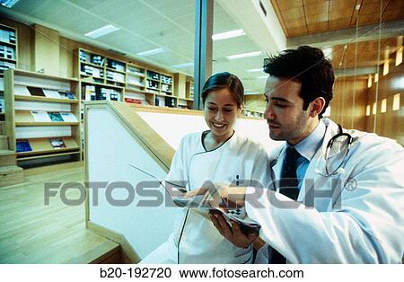 Doctor and nurse consulting medical magazine View Large Photo Image Stock Image - Doctor and nurse consulting medical magazine. Fotosearch