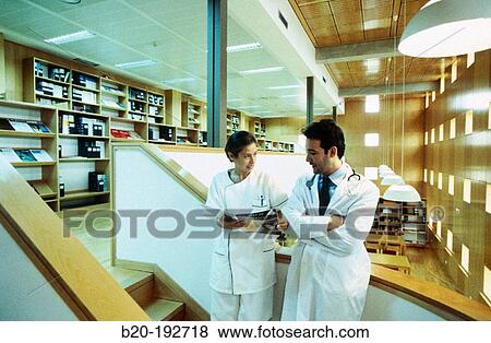 Doctor and nurse consulting medical magazine View Large Photo Image Stock Photo - Doctor and nurse consulting medical magazine. Fotosearch