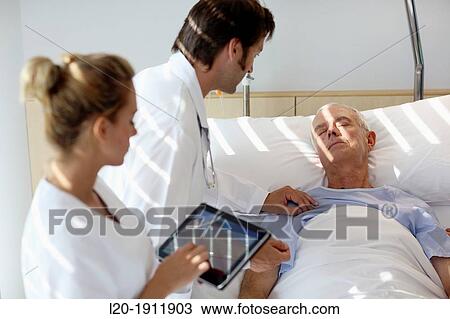 Stock Image - doctor attending to patient in hospital room, Onkologikoa Hospital, Oncology Institute, Case Center for prevention, diagnosis and treatment of cancer, Donostia, San Sebastian, Gipuzkoa, Basque Country, Spain. Fotosearch