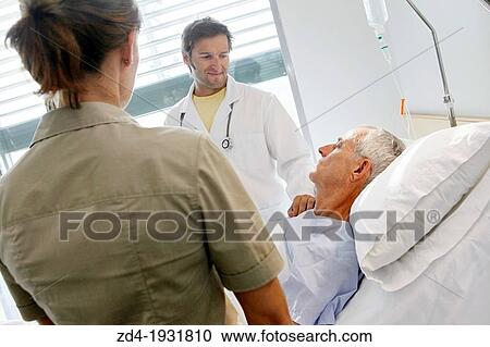Stock Image - doctor attending to patient in hospital room, Onkologikoa Hospital, Oncology Institute, Case Center for prevention, diagnosis and treatment of cancer, Donostia, San Sebastian, Gipuzkoa, Basque Country, Spain. Fotosearch