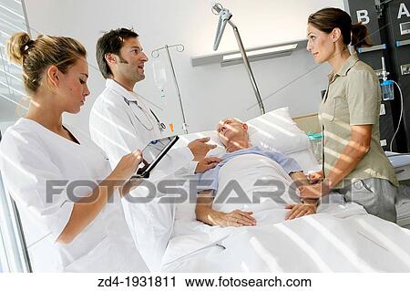 Stock Image - doctor attending to patient in hospital room, Onkologikoa Hospital, Oncology Institute, Case Center for prevention, diagnosis and treatment of cancer, Donostia, San Sebastian, Gipuzkoa, Basque Country, Spain. Fotosearch