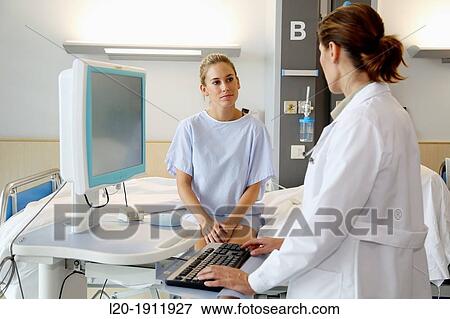 Stock Photo - doctor attending to patient in hospital room, Onkologikoa Hospital, Oncology Institute, Case Center for prevention, diagnosis and treatment of cancer, Donostia, San Sebastian, Gipuzkoa, Basque Country, Spain. Fotosearch