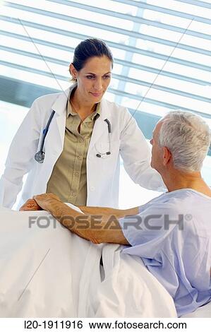 Stock Photograph - doctor attending to patient in hospital room, Onkologikoa Hospital, Oncology Institute, Case Center for prevention, diagnosis and treatment of cancer, Donostia, San Sebastian, Gipuzkoa, Basque Country, Spain. Fotosearch
