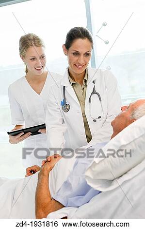 Stock Photograph - doctor attending to patient in hospital room, Onkologikoa Hospital, Oncology Institute, Case Center for prevention, diagnosis and treatment of cancer, Donostia, San Sebastian, Gipuzkoa, Basque Country, Spain. Fotosearch