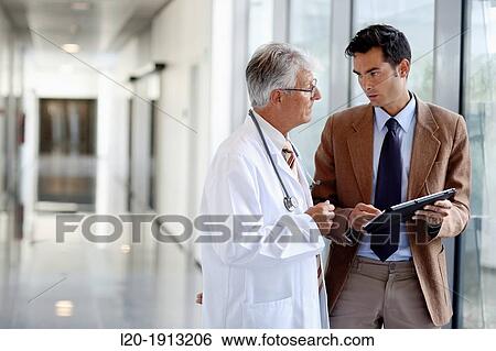 Stock Photograph - Doctor attending to seller, Corridor, Onkologikoa Hospital, Oncology Institute, Case Center for prevention, diagnosis and treatment of cancer, Donostia, San Sebastian, Gipuzkoa, Basque Country, Spain. Fotosearch