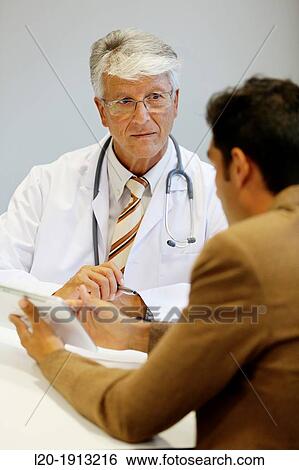 Stock Photograph - Doctor attending to seller, Tablet, Consulting room, Onkologikoa Hospital, Oncology Institute, Case Center for prevention, diagnosis and treatment of cancer, Donostia, San Sebastian, Gipuzkoa, Basque Country, Spain. Fotosearch