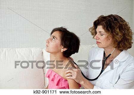 Stock Image - Doctor examining teenager. Fotosearch