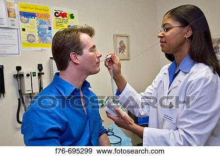 Doctor / Family physician taking temperature of 40 year old male patient using digital thermometer View Large Photo Image Stock Photo - Doctor / Family physician taking temperature of 40 year old male patient using digital thermometer. Fotosearch