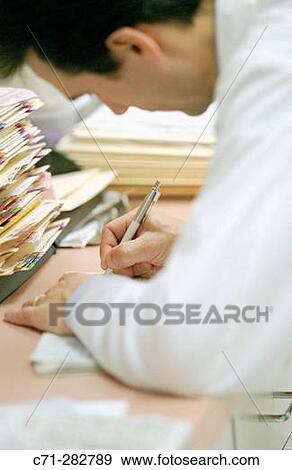 Doctor filling patient chart View Large Photo Image Stock Photo - Doctor filling patient chart. Fotosearch