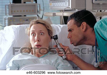 Doctor inspecting patient's ear View Large Photo Image Stock Photograph - Doctor inspecting patient's ear. Fotosearch