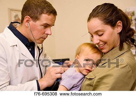 Doctor / pediatrician examines baby girl being held by her mother View Large Photo Image Stock Photo - Doctor / pediatrician examines baby girl being held by her mother. Fotosearch