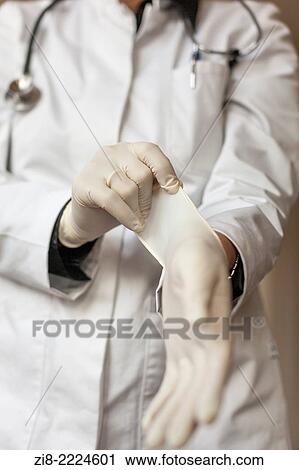 Doctor puts on sterile surgical gloves. View Large Photo Image Stock Image - Doctor puts on sterile surgical gloves.. Fotosearch