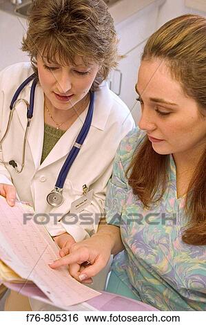 Doctor reviewing medical charts with nurse, in medical office View Large Photo Image Stock Photograph - Doctor reviewing medical charts with nurse, in medical office. Fotosearch