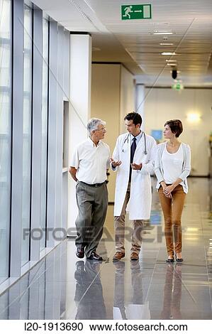Stock Image - Doctor talking with the patient's family in the hospital corridor, Onkologikoa Hospital, Oncology Institute, Case Center for prevention, diagnosis and treatment of cancer, Donostia, San Sebastian, Gipuzkoa, Basque Country, Spain. Fotosearch