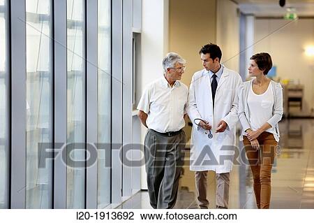 Stock Image - Doctor talking with the patient's family in the hospital corridor, Onkologikoa Hospital, Oncology Institute, Case Center for prevention, diagnosis and treatment of cancer, Donostia, San Sebastian, Gipuzkoa, Basque Country, Spain. Fotosearch
