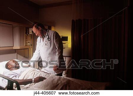 Stock Photo - Doctor with black man patient in hospital room. Fotosearch