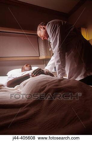 Doctor with black man patient in hospital room View Large Photo Image Stock Photo - Doctor with black man patient in hospital room. Fotosearch