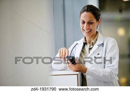 Stock Image - Doctor with smartphone in corridor, Onkologikoa Hospital, Oncology Institute, Case Center for prevention, diagnosis and treatment of cancer, Donostia, San Sebastian, Gipuzkoa, Basque Country, Spain. Fotosearch