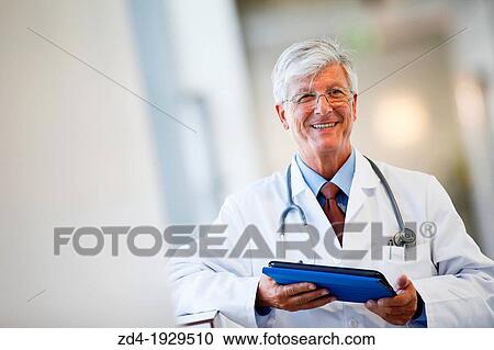 Stock Image - Doctor with tablet in corridor, Onkologikoa Hospital, Oncology Institute, Case Center for prevention, diagnosis and treatment of cancer, Donostia, San Sebastian, Gipuzkoa, Basque Country, Spain. Fotosearch
