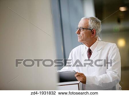 Stock Image - Doctor with tablet in corridor, Onkologikoa Hospital, Oncology Institute, Case Center for prevention, diagnosis and treatment of cancer, Donostia, San Sebastian, Gipuzkoa, Basque Country, Spain. Fotosearch