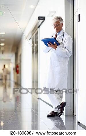 Stock Photo - Doctor with tablet in corridor, Onkologikoa Hospital, Oncology Institute, Case Center for prevention, diagnosis and treatment of cancer, Donostia, San Sebastian, Gipuzkoa, Basque Country, Spain. Fotosearch