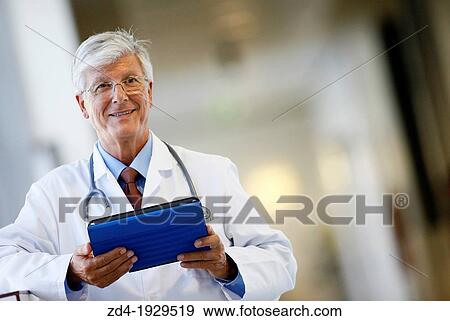 Stock Photo - Doctor with tablet in corridor, Onkologikoa Hospital, Oncology Institute, Case Center for prevention, diagnosis and treatment of cancer, Donostia, San Sebastian, Gipuzkoa, Basque Country, Spain. Fotosearch